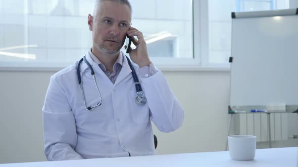 Doctor Talking on Phone in His Cabinet