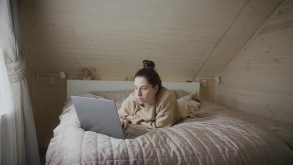 Concentrated woman works on laptop