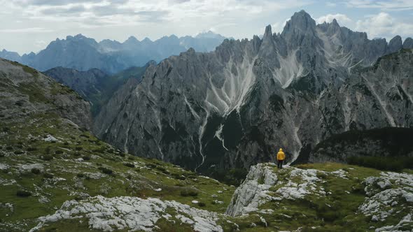 Aerial View of Man in Yellow Coat in Front of Auronzo Di Cadore of Cadini Di Misurina Mountains