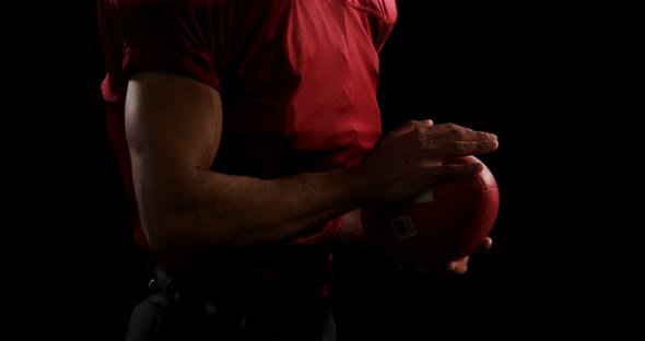 American football player holding a ball with both his hands