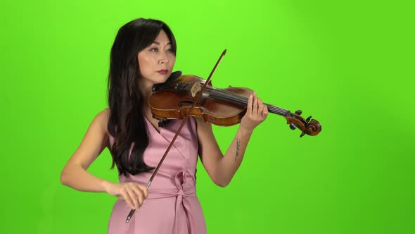 Girl of Asian Appearance Playing the Violin. Green Screen