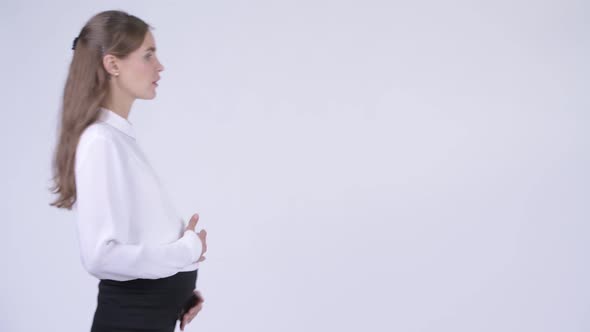 Profile View of Young Tired Pregnant Businesswoman Walking