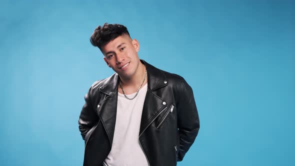 Confident man looking at camera and smiling while folding his arms against an isolated background.