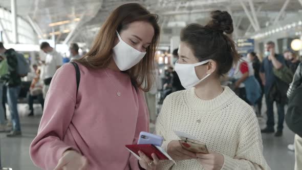 Two Women in Medical Mask Portrait Laughing and Talking in Airport Terminal Preventing Themselves