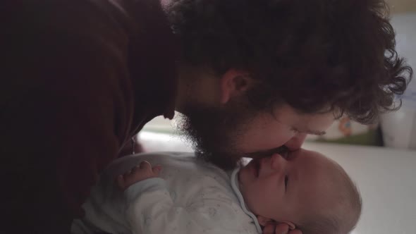 Father interacting with newborn baby at home