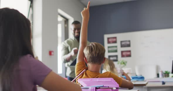 Video of happy african american male teacher during lesson with class of diverse pupils