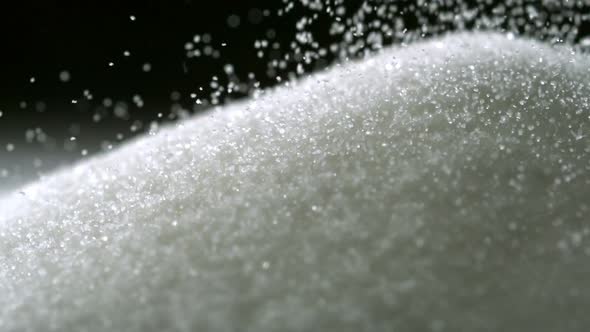 Pile of sugar on black background, Slow Motion alt