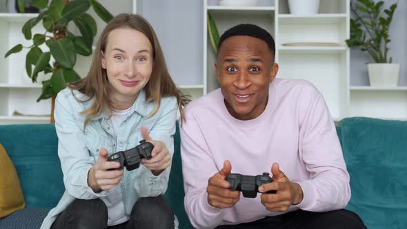 Happy Interracial Couple Playing Video Games Together at Home