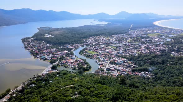 Aerial drone scene of city between ocean and river tropical urbanism
