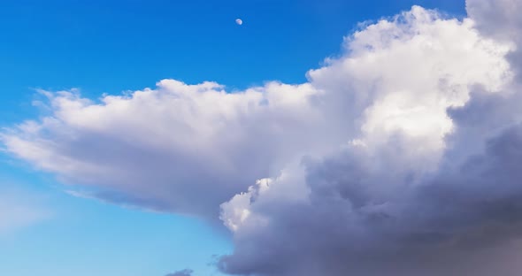 Puffy Cumulus Clouds with Moon Moving Fast Across the Sky