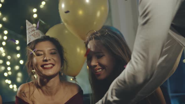 Young Woman Blowing Out Fire on Candles and Making Wish at Party or Celebration