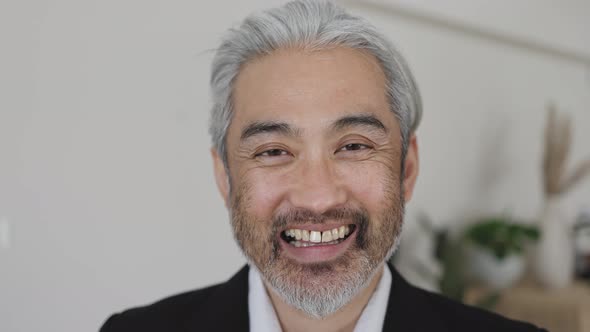 Happy Asian business man smiling in camera