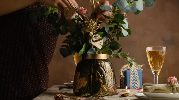 Young Woman Decorates Bouquet of Flowers in Vase