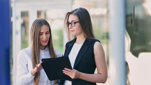 Two Female Businesswoman Having Informal Team Meeting Standing Outdoor Near Office