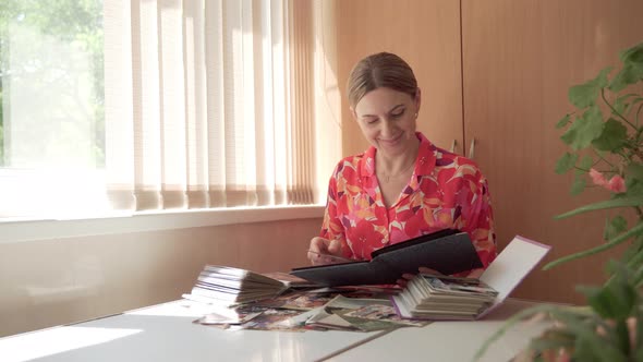 Woman with Great Interest Looks Through Old Photos Remembering Her Past Life