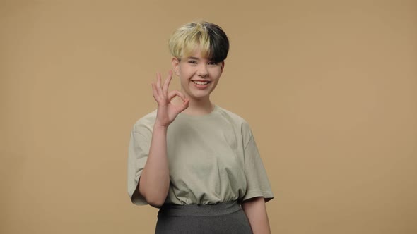 Portrait of Fashion Model Looking at Camera Making Sign Ok and Smiling