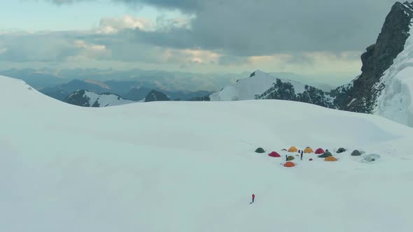 Camping and Snowy Mountains in European Alps at Sunset. Aerial View