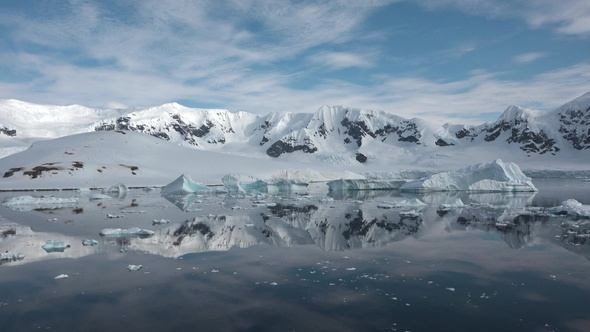 Icebergs are reflected in the water. Antarctic Nature. Majestic winter landscape.