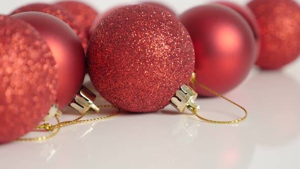 Golden strings attached on red Christmas baubles slow tilt 4K video