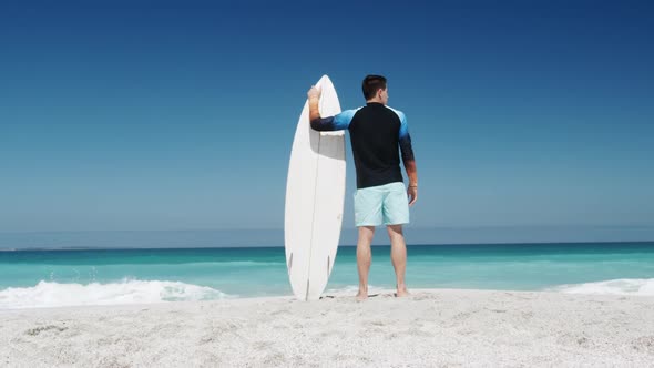 Man holding a surfboard on the beach