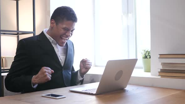 Black Businessman Celebrating Success, Working on Laptop