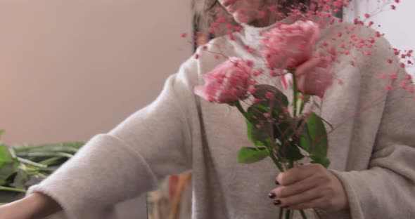 Florist woman making bouquet in flower shop, closeup hands. Floral business concept.