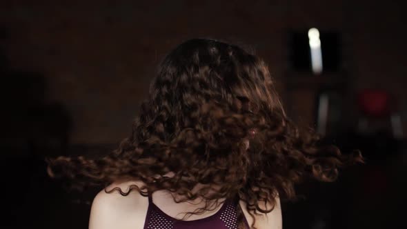 Girl Brandishes Hair. Close-up of the Girl Who Brandishes Beautiful Curly Hair on Camera and Smiles