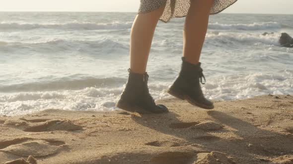 Closeup Cinematic Shot of Woman Feet in Boots Walking on the Beach at Sunset or Sunrise