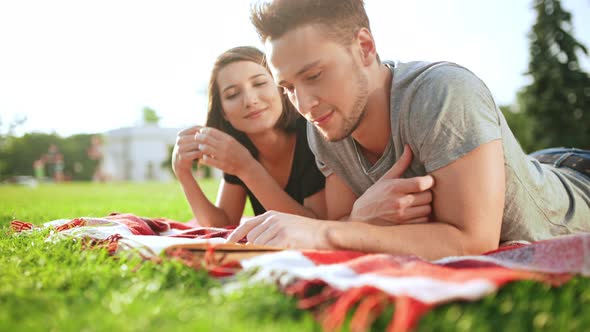 Young Beautiful Couple Reading Book Smiling Resting in Park