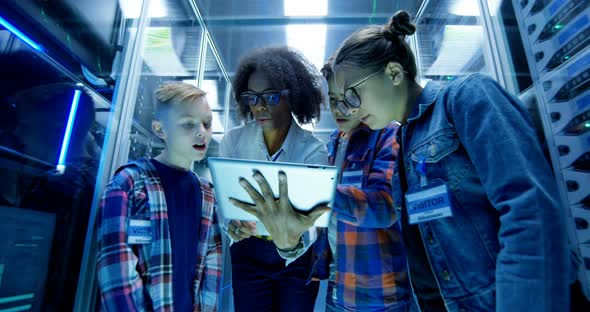 Female Technician Showing Tablet To Children