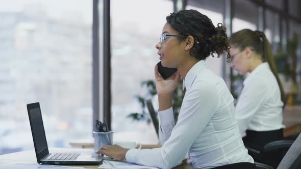 Smiling Cheerful Female Worker Talking on Smartphone With Client, Teamwork