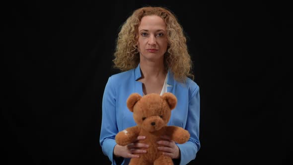 Portrait of Serious Caucasian Woman Holding Teddy Bear Looking at Camera