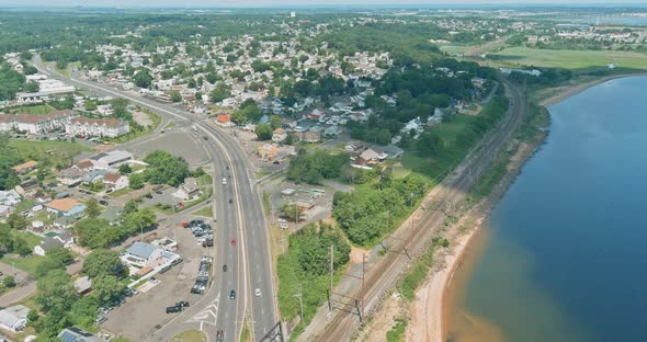 Aerial View Interstate Highway Road Going Through the American Small Town Near the Coastline Bay