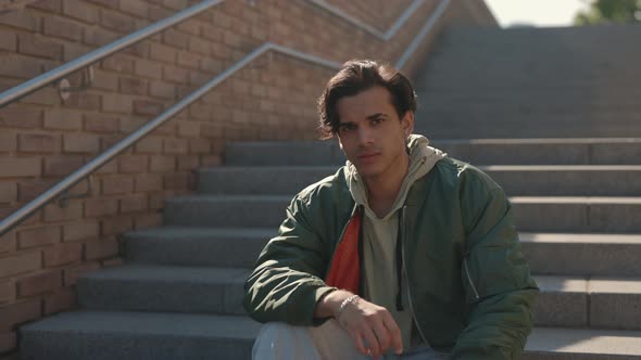 Portrait of Confident Stylish Guy Sitting on Stairs Outdoors