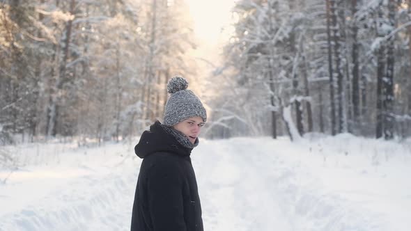 man in winter clothes walks through winter forest. Beautiful nature in Park.