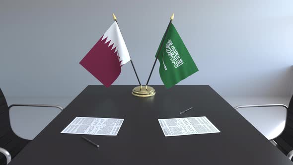 Flags of Qatar and Saudi Arabia on the Table
