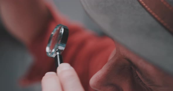 Young man examines using magnifying glass