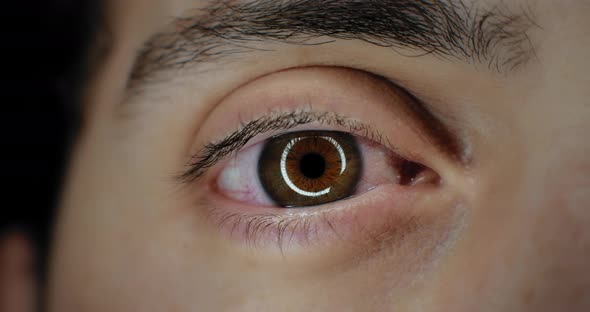 Close up of a man's brown eye opening in a bright studio lighting, slow motion