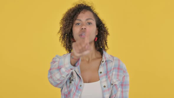 Young African Woman Pointing at the Camera on Yellow Background