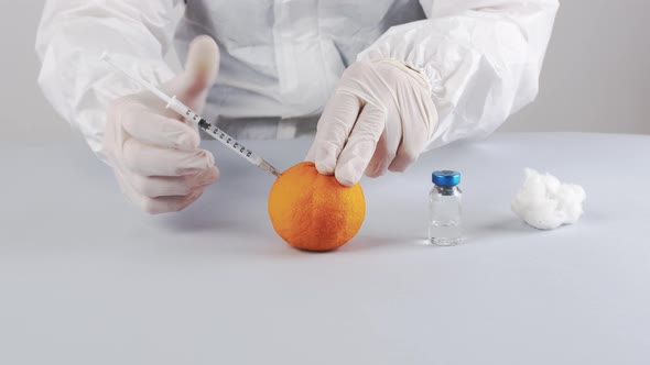 Doctor is learning to do the puncture with an orange fruit