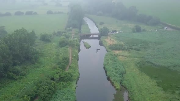 Aerial amazing view of the ecosystem at the River Otter in Devon, England, Drone gains height and fl