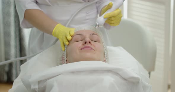 The Doctor Performs Cosmetic Procedures In A Beauty Salon On The Face Of A Young Woman