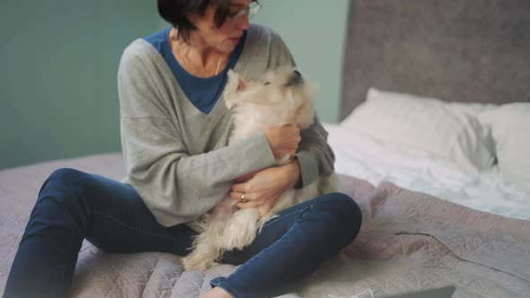 Cheerful mature woman hugging dog