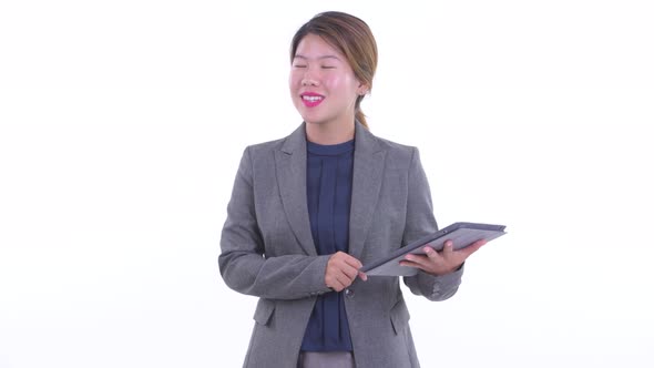 Happy Young Asian Businesswoman Thinking While Using Digital Tablet