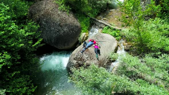 Man And Woman Lying On Stone In River