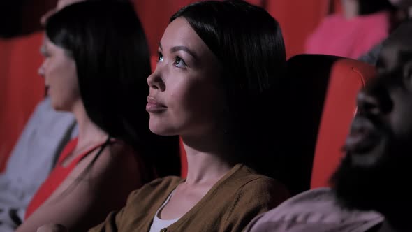 Asian Female Moviegoer Eating Popcorn at Cinema