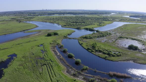 Scenic Aerial View of a River and Green Fields in a Countryside
