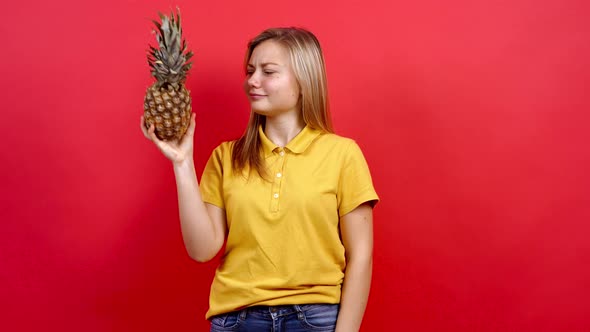 Cute and Slightly Fat Girl in a Yellow T-shirt Who Keeps Fresh Pineapple in Her Hand,