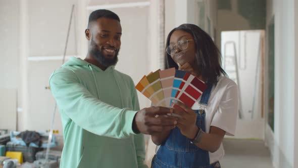 Married Young African Couple Choosing Walls Color for New Apartment