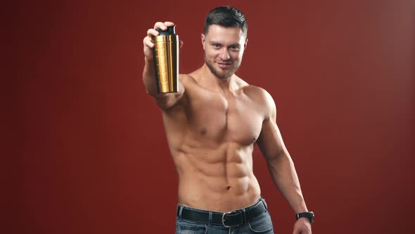Attractive bodybuilder guy with protein shake. Portrait of a sportsman with muscular body. 